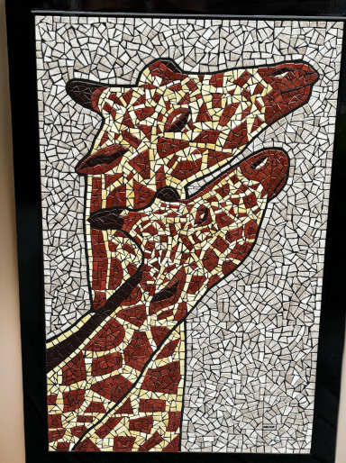 Mosaïque représentant deux girafes avec des motifs brun et jaune sur fond clair.