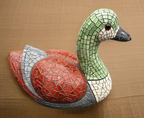 Canard en mosaïque avec un corps coloré et un bec noir.